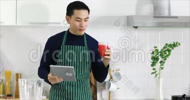 亚洲人用平板电脑喝果汁。